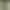 Eine grüne Pflanze in einem Korb aus Weide hängt nahe einem Fenster mit Kerzen und Steinen in einem Steintopf.